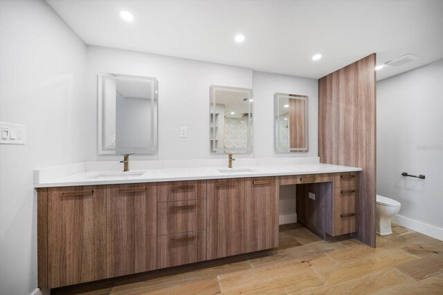 full bathroom featuring a sink, recessed lighting, toilet, and double vanity