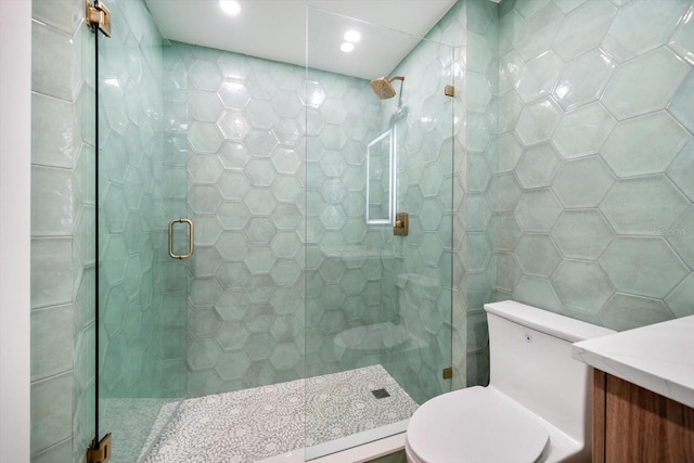bathroom featuring vanity, toilet, tile walls, recessed lighting, and a stall shower