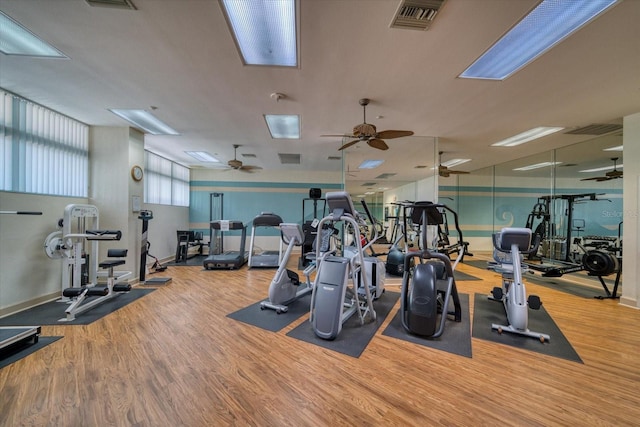 exercise room with ceiling fan, visible vents, and wood finished floors