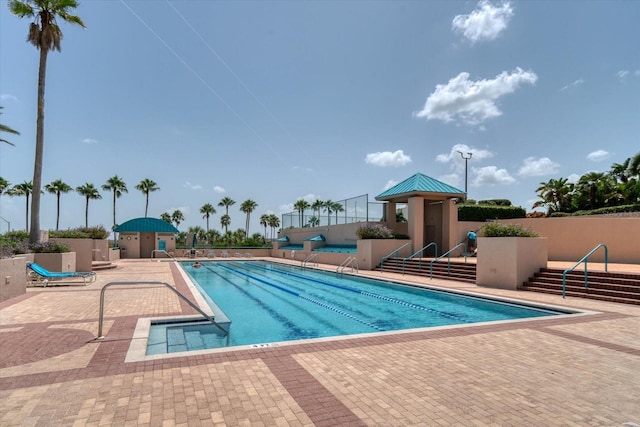 community pool featuring a patio and fence