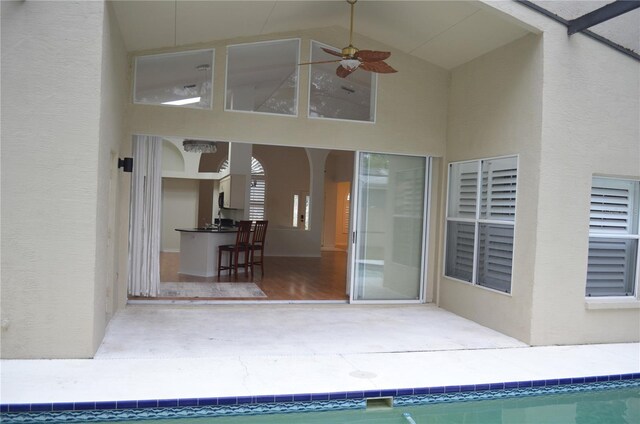exterior space with a ceiling fan, a patio area, stucco siding, and an outdoor pool