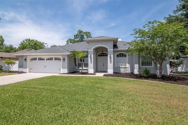 view of front of home with concrete driveway, a front yard, an attached garage, and stucco siding