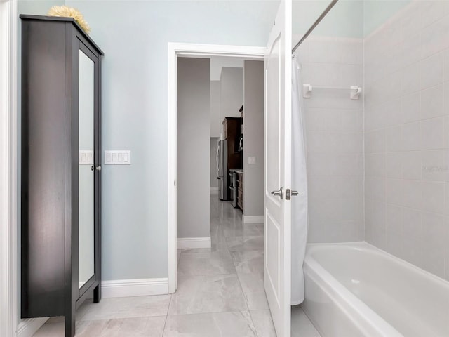 full bathroom with marble finish floor, shower / bathtub combination with curtain, and baseboards
