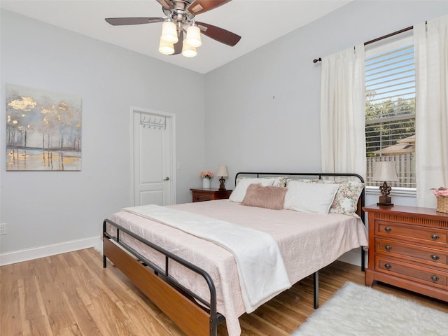 bedroom with baseboards, light wood-type flooring, and a ceiling fan