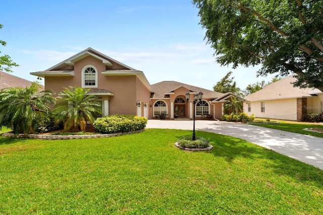 4022 Valrico Grove Dr, Valrico, FL 33594 - mediterranean / spanish-style house with curved driveway, stucco siding, and a front yard