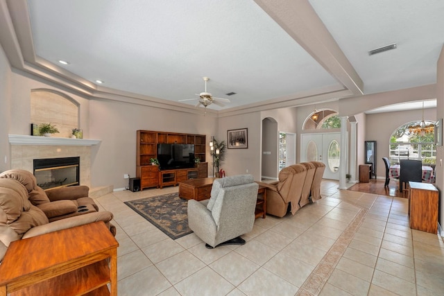 4022 Valrico Grove Dr, Valrico, FL 33594 - living room featuring arched walkways, a tray ceiling, light tile patterned floors, a tiled fireplace, and recessed lighting