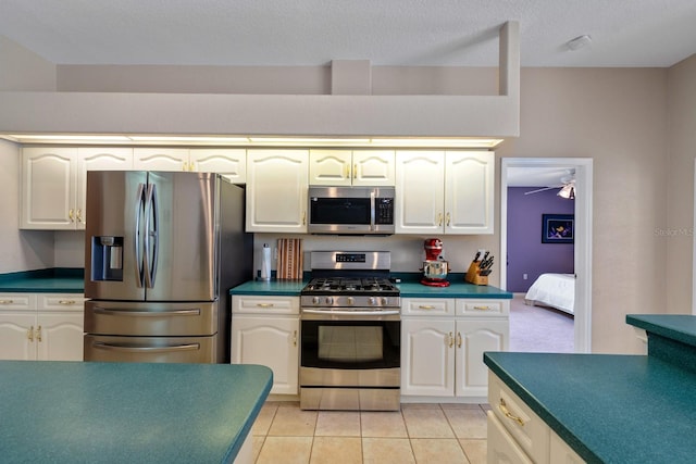 4022 Valrico Grove Dr, Valrico, FL 33594 - kitchen with stainless steel appliances, dark countertops, light tile patterned floors, and a textured ceiling