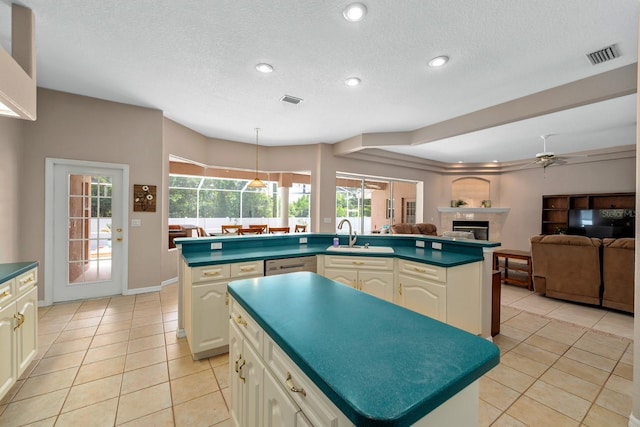 4022 Valrico Grove Dr, Valrico, FL 33594 - kitchen with a kitchen island, a tile fireplace, a sink, dark countertops, and light tile patterned floors