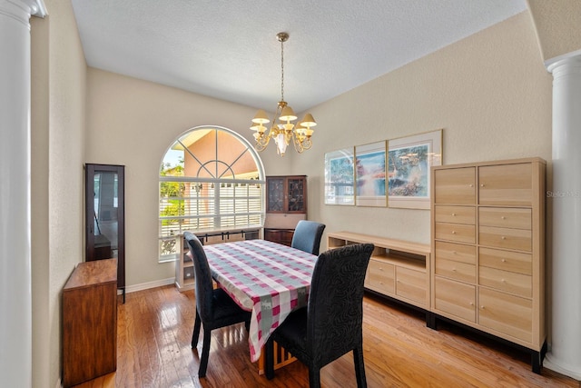4022 Valrico Grove Dr, Valrico, FL 33594 - dining area with ornate columns, light wood-style flooring, a chandelier, a textured wall, and a textured ceiling