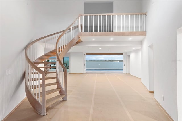 stairs featuring recessed lighting and a high ceiling