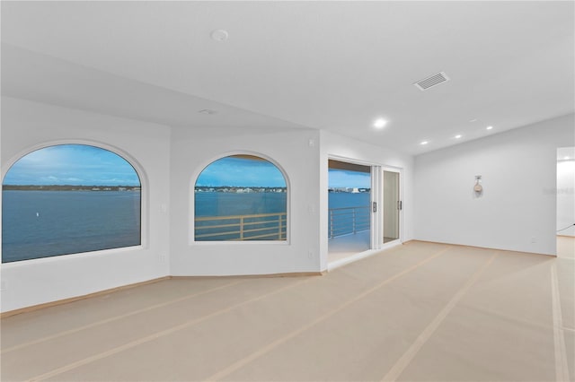 spare room featuring recessed lighting, visible vents, a water view, and baseboards