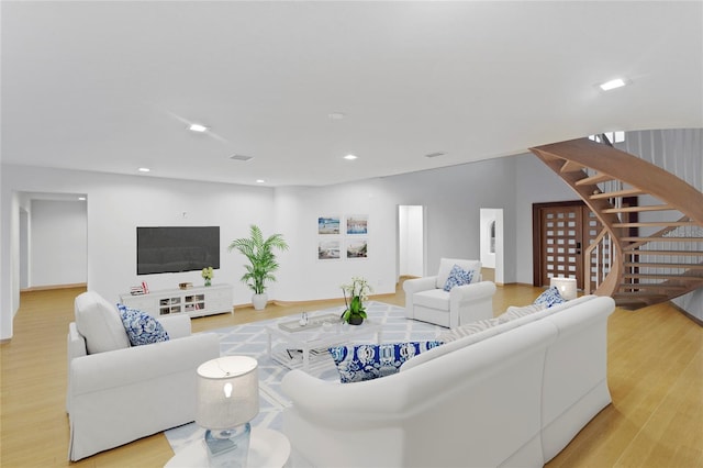 living room with visible vents, stairway, light wood-style floors, and recessed lighting