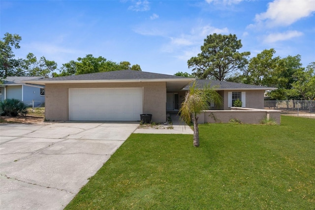 single story home featuring driveway, fence, stucco siding, a front lawn, and a garage