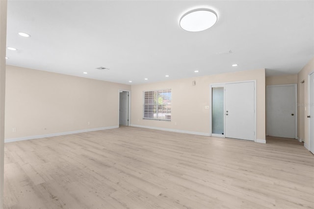 unfurnished living room featuring baseboards, light wood-type flooring, visible vents, and recessed lighting
