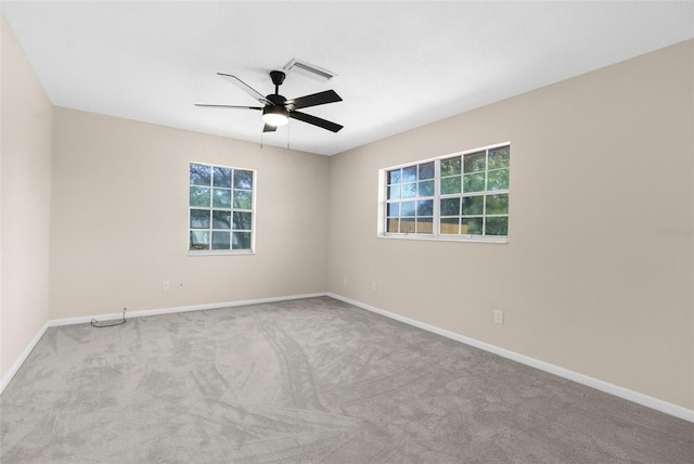 empty room with a ceiling fan, visible vents, carpet floors, and baseboards