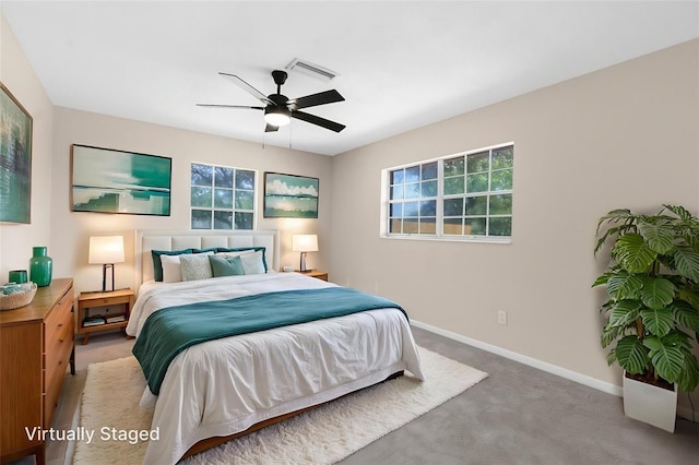 bedroom featuring visible vents, multiple windows, light carpet, and baseboards