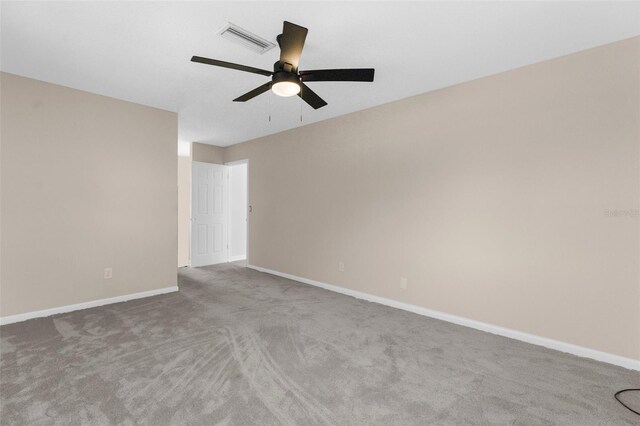 empty room with baseboards, visible vents, a ceiling fan, and carpet floors