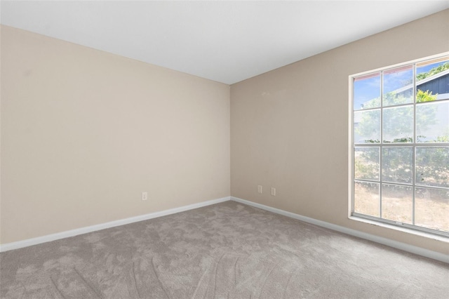 carpeted empty room with baseboards