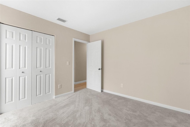 unfurnished bedroom with visible vents, a closet, baseboards, and carpet floors