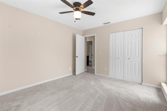 unfurnished bedroom featuring light colored carpet, visible vents, ceiling fan, a closet, and baseboards