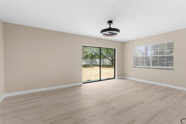 spare room with light wood-style flooring and baseboards