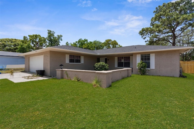 back of house with stucco siding, a lawn, concrete driveway, an attached garage, and fence
