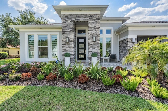 property entrance with stucco siding, a garage, and stone siding