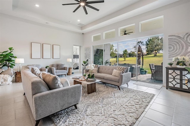 living area with recessed lighting, a ceiling fan, visible vents, a towering ceiling, and tile patterned flooring