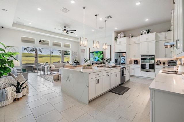 kitchen with open floor plan, visible vents, ceiling fan, and stainless steel appliances