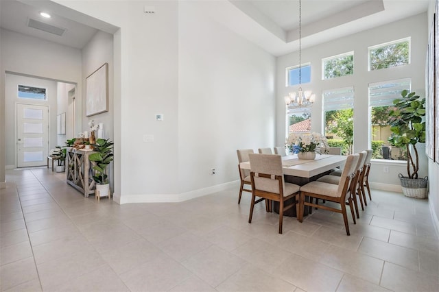 dining space featuring an inviting chandelier, baseboards, visible vents, light tile patterned flooring, and a towering ceiling