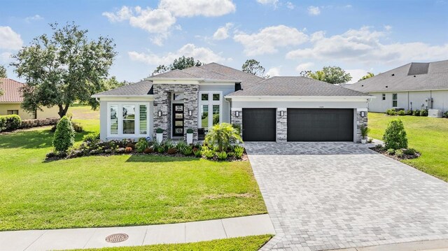 view of front of house with stone siding, a front yard, decorative driveway, and an attached garage