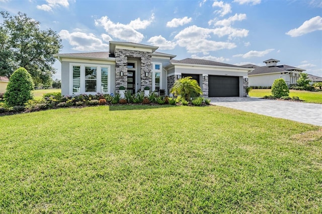 prairie-style house with decorative driveway, a front lawn, stone siding, and a garage