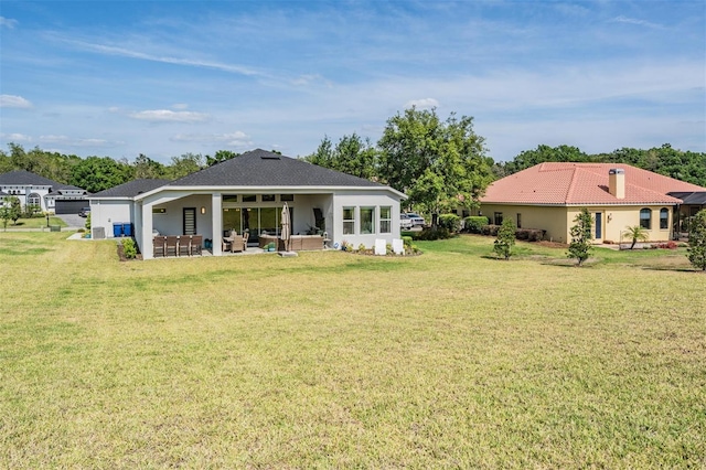 rear view of house featuring a chimney, stucco siding, an outdoor hangout area, a patio area, and a lawn