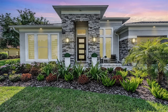 entrance to property with a garage and stone siding