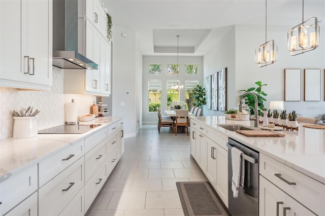 kitchen featuring a notable chandelier, black electric stovetop, wall chimney exhaust hood, backsplash, and stainless steel dishwasher