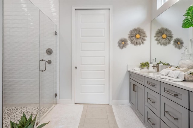 full bathroom featuring tile patterned floors, a shower stall, vanity, and baseboards