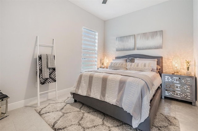 bedroom with ceiling fan, tile patterned floors, and baseboards