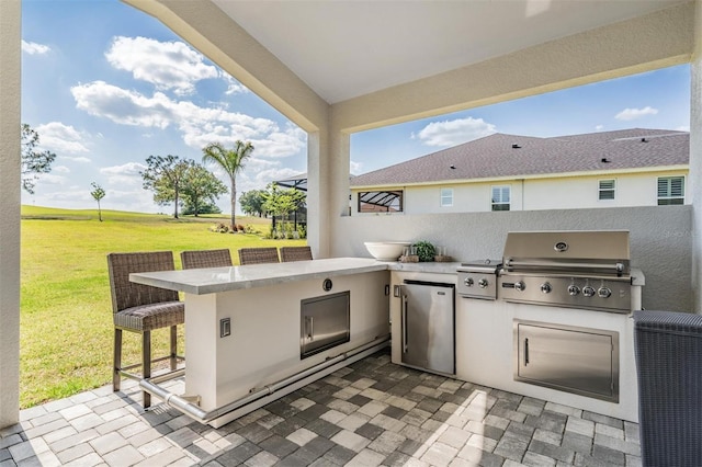 view of patio / terrace featuring a grill, area for grilling, and outdoor wet bar