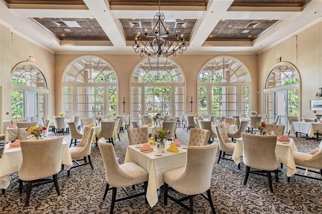 dining space with an inviting chandelier, crown molding, coffered ceiling, and a high ceiling