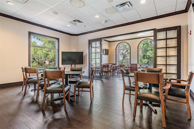dining room featuring dark wood-type flooring, visible vents, ornamental molding, and baseboards