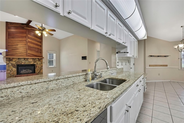 kitchen with white cabinets, ceiling fan with notable chandelier, and a sink