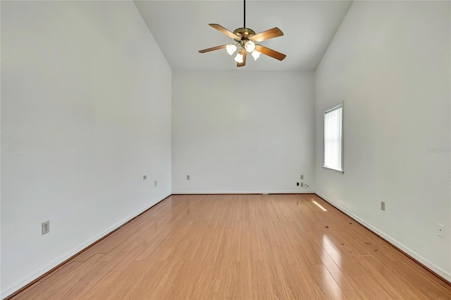 unfurnished room featuring wood finished floors, ceiling fan, vaulted ceiling, and baseboards