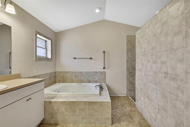 full bathroom with vaulted ceiling, vanity, tile patterned flooring, and a jetted tub
