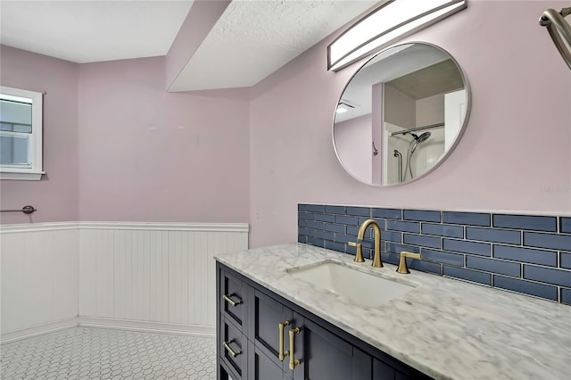 bathroom with tasteful backsplash, wainscoting, and vanity