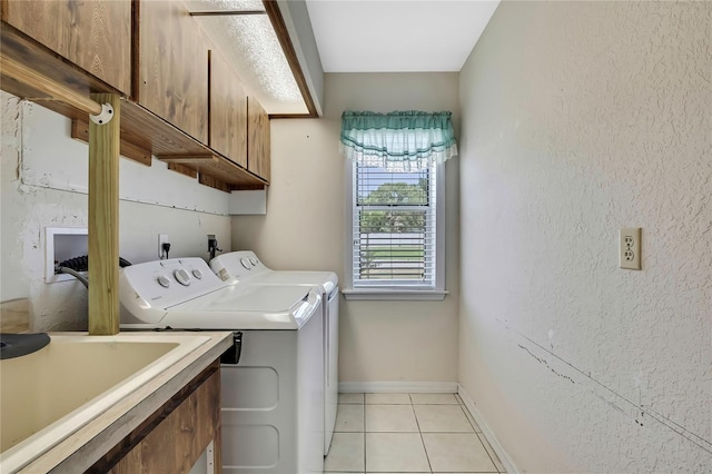 laundry room with a sink, cabinet space, independent washer and dryer, light tile patterned floors, and baseboards