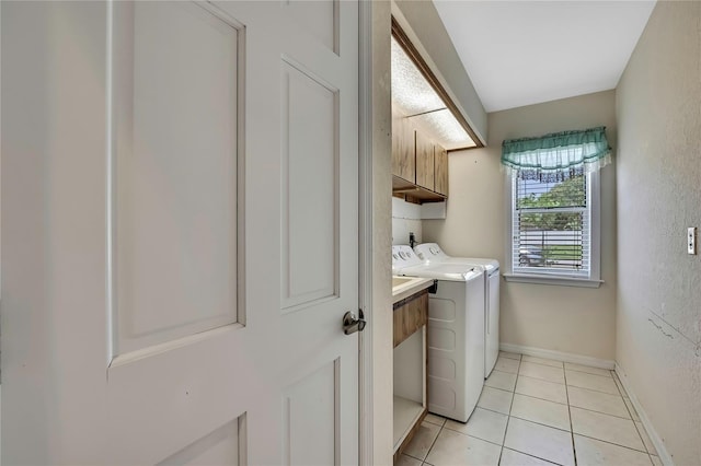 laundry room with baseboards, light tile patterned floors, cabinet space, and independent washer and dryer