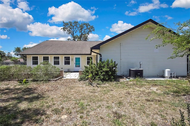 back of house with a shingled roof, central air condition unit, and a patio