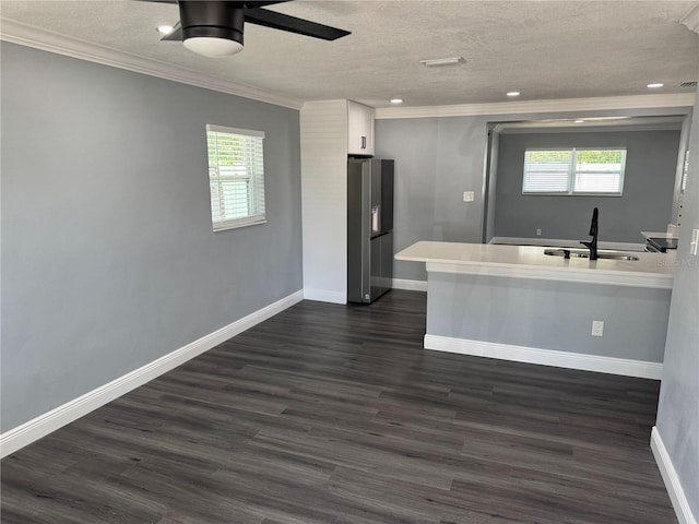 kitchen featuring a textured ceiling, stainless steel fridge, a sink, and a healthy amount of sunlight