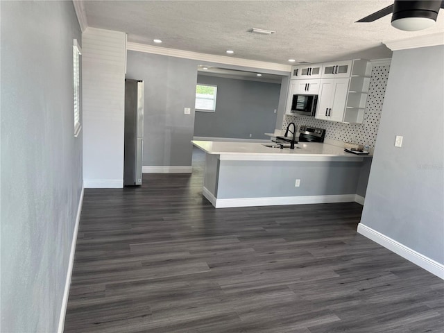 kitchen featuring open shelves, a peninsula, white cabinets, a sink, and appliances with stainless steel finishes