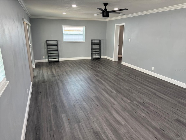 spare room with baseboards, ornamental molding, dark wood-style flooring, and ceiling fan